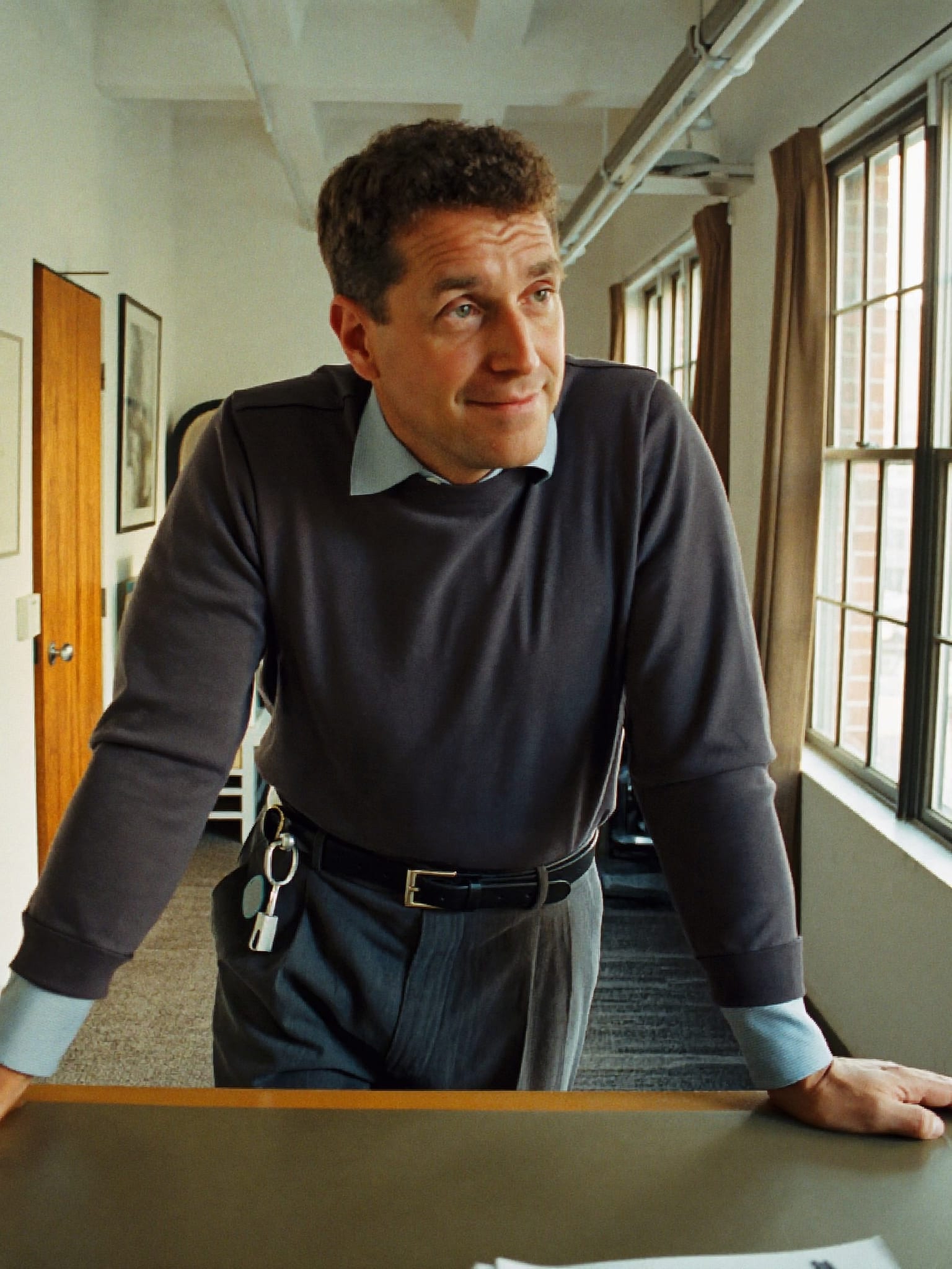 A founder leaning on a desk in a bright loft office